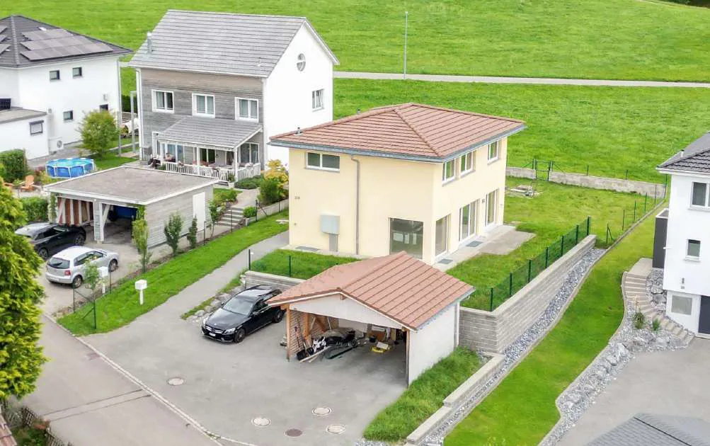 Einfamilienhaus mit Garten und Carport aus der Luft